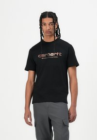 Black short-sleeve t-shirt featuring the Carhartt logo in red and white on the front, made of soft fabric with a relaxed fit.