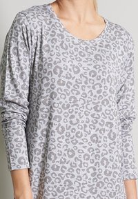 Grå långärmad t-shirt med rundad hals och leopardmönster i mörkare grått. Tyget verkar mjukt med en något texturerad yta.