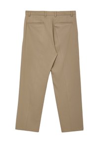 Pantaloni beige con vestibilità su misura, dotati di due tasche posteriori, una superficie liscia e dettagli plissettati sulla parte anteriore. Presentano passanti per cintura.