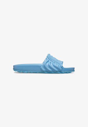 Light blue slide sandal made of rubber, featuring a wavy textured upper and a flat sole with a textured grip pattern.