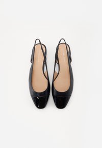 Escarpins noirs à talon avec une finition en cuir lisse, bout rond avec un cap en vernis brillant et une semelle intérieure rembourrée.