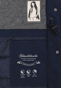 Mornarica vodootporna jakna sivi flis panel, oznaku s logotipom i tiskane upute za njegu. Uključuje reguliranu uže i metalne kopče.