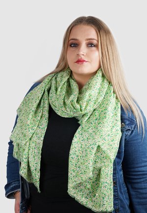Lichtgroene sjaal met een gespikkeld patroon in donkerder groentinten en beige. Zachte textuur, gelaagde draping en rafelige randen.