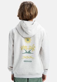 Šedá mikina s klokánkovou kapsou, na zadní straně s barevným grafikou slunce a palmových stromů. Vyrobena z jemného strukturovaného materiálu.