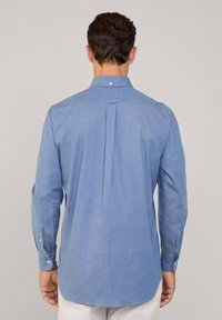 Lichtblauw overhemd met lange mouwen van katoen, met een button-down kraag, een centrale rugplooi en een ronde zoom. Gedetailleerde knoopmanchetten.