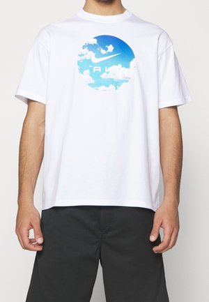 Camiseta de algodón blanca con un gráfico circular de cielo azul y nubes con el logo de Nike. Diseño de mangas cortas y un corte relajado.