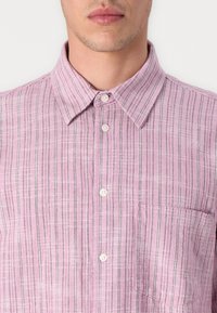 Light pink linen shirt with vertical stripes in darker pink and gray. Features a button-up collar and a single breast pocket.