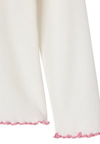 White ribbed long sleeves with pink ruffled trim at the cuffs.