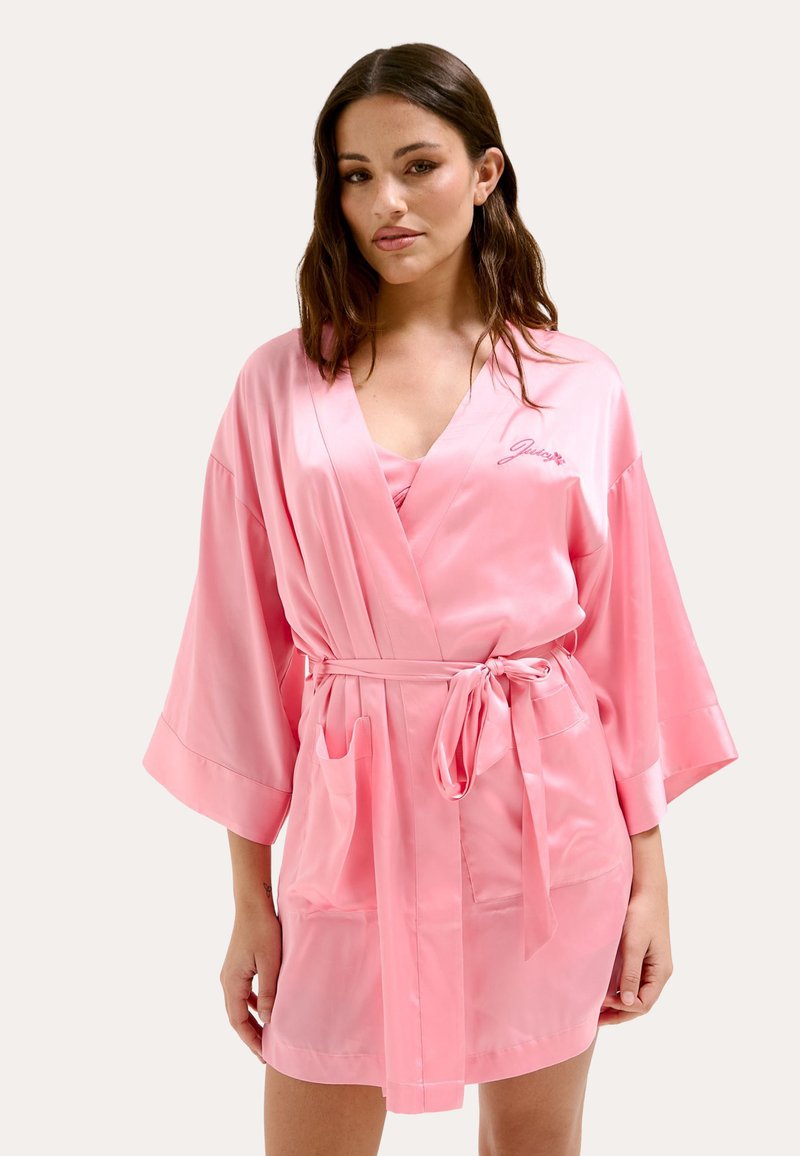 Robe en satin rose avec de larges manches kimono, une ceinture à nouer et deux poches avant ; présente un logo brodé sur la poitrine gauche.