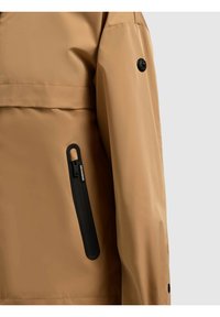 Bežna jakna z detajlom na rokavu in strani, z vertikalnim črnim gumiranim žepom z zadrgo ter črnim gumbom na rokavu.