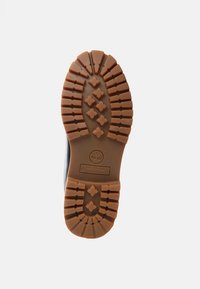 Suela de bota de goma marrón con texturas y logotipo. Presenta un patrón cruzado para tracción y durabilidad. Perfil plano; diseño robusto.