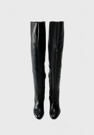 Over-the-knee black leather boots with a smooth finish, pointed toes, and side zippers. Features a fitted design for a sleek silhouette.