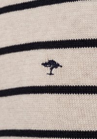 Strickpullover mit cremefarbenem Grund und marineblauen horizontalen Streifen. Mit kleinem marinen Baumlogo, weicher Textur und lässigem Design.