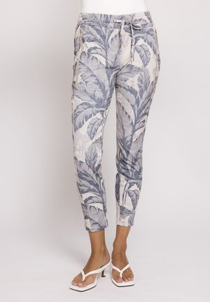 Slim-fit cropped pants with gray palm leaf print, drawstring waist, side pockets, worn with white heeled sandals.