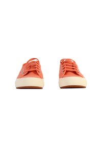 Zapatillas de lona naranja con punta redonda, suela de goma blanca y cordones a juego. Presentan una puntera texturizada y un logotipo sutil en el lateral.
