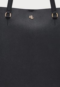 Borsa a tracolla nera realizzata in materiale sintetico texturizzato. Presenta metalleria dorata e logo impressa sul davanti. Doppi manici per la spalla.