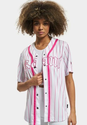 White short-sleeve jersey with vertical pink stripes, snap buttons, and bold pink script across the chest. Lightweight, breathable fabric.