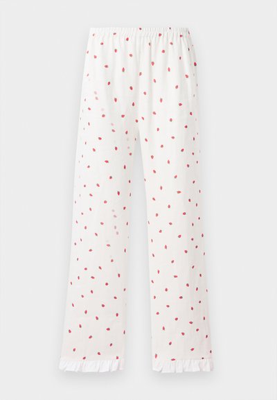 Ανατέλλουν λευκές πιτζάμες με κόκκινο σχέδιο φράουλας, ελαστική μέση και φρουφρού στριφώματα. Ελαφρύ ύφασμα και ευθεία γραμμή σχεδίασης.