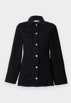 Zwarte spijkerjas met een kraag, zilverkleurige drukknoopsluitingen, twee voorzakken en een getailleerd ontwerp. Voorzien van lange, klokvormige mouwen.