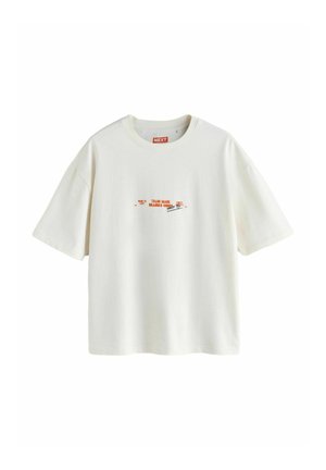 Biała koszulka z krótkim rękawem, na środku klatki piersiowej znajduje się mały czerwono-czarny napis i grafika, okrągły dekolt, luźny krój.