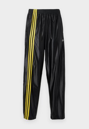 Pantalones deportivos negros de material brillante con cintura elástica, que presentan dos rayas amarillas a lo largo del costado y un pequeño logo.