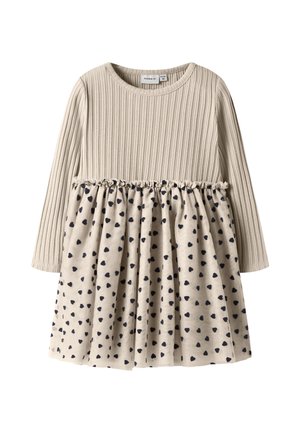 Robe beige à manches longues pour tout-petit avec un haut en tricot côtelé et une jupe froncée ornée de petits cœurs bleu marine.