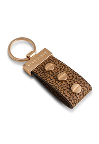 Porte-clés en cuir marron présentant un motif texturé, des accessoires en métal doré et trois accents ronds décoratifs. Anneau en métal circulaire attaché.