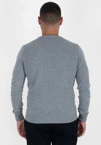 Szary sweter dziergany z okrągłym dekoltem, długimi rękawami oraz ściągaczami na mankietach i u dołu. Materiał wydaje się miękki i teksturowany. Przedstawiony widok z tyłu.