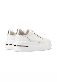 Sneakers platform bianchi con accenti metallici dorati sul tallone e sul lato. Texture in pelle liscia con una suola lucida e robusta.