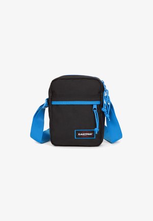 Borsa a tracolla nera in tessuto con dettagli blu. Presenta una forma rettangolare, una tracolla regolabile, chiusura con zip e un’etichetta con il marchio sul davanti.