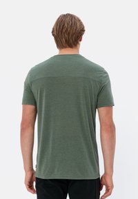 Groene korte mouw t-shirt van zachte stof, met een ronde halslijn en een rechte zoom. Soepele textuur met minimale ontwerpelementen.