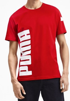 Rood katoenen T-shirt met een groot wit "PUMA"-logo dat verticaal aan de linkerzijde is gedrukt. Korte mouwen en een ronde hals.