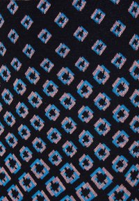 Mönstrad tyg med marinblå bakgrund och sammanlänkade rosa och blå diamantformer. Slät textur med stickad utseende.