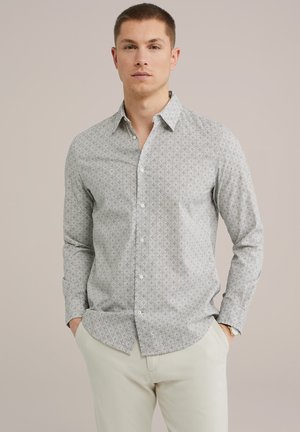 Camisa de botones en tela gris claro con un intrincado estampado geométrico. Mangas largas con puños de botón, bolsillo en el pecho y dobladillo recto.