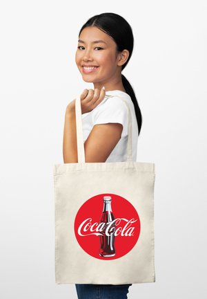 Torba na ramię z płótna w kolorze kremowym z czerwonym okrągłym wzorem przedstawiającym butelkę Coca-Coli oraz logo. Prosty design z mocnymi uchwytami.