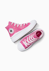 Baskets Converse en toile rose, avec des semelles en caoutchouc blanches, des œillets et des lacets. La version montante a un patch logo circulaire. Design plat avec une texture lisse.