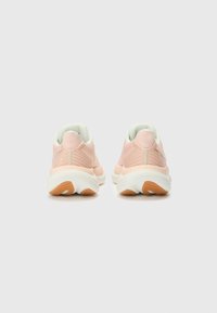 Zapatillas de malla rosa con suelas blancas y un respaldo texturizado. Collar suave en verde menta y suela de goma con acentos naranjas.
