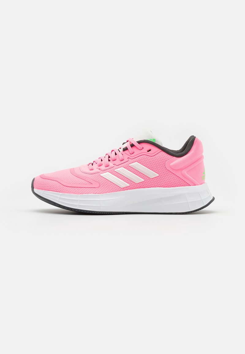 Růžové sportovní boty s prodyšným síťovaným svrškem, bílými pruhy a polstrovanou bílou podrážkou. Na patě a jazyku mají šedé akcenty.