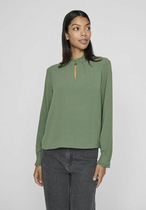 Groene blouse met lange mouwen, voorzien van een ronde halslijn met een sleutelgatdetail, textuurstof en gerimpelde manchetten.