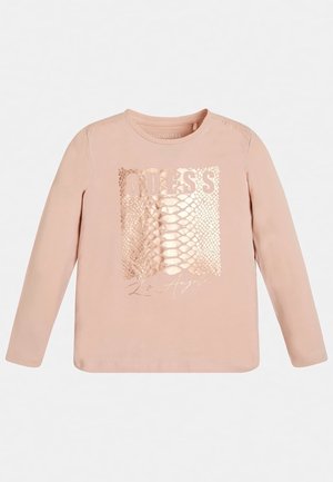 Chemise rose clair à manches longues avec motif peau de serpent métallique et texte "GUESS Los Angeles" sur le devant.