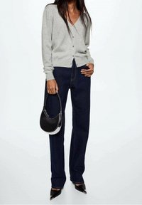 Szary kardigan na guziki, zestawiony z ciemnoniebieskimi, wysokim stanem jeansami i czarnymi szpilkami o szpiczastych noskach. Do tego czarna i biała torebka jako dodatek.