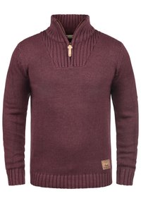 Dunkelroter Strickpullover mit einem Viertel-Reißverschluss, geripptem Kragen und Saum sowie einem kleinen Leder-Brandlogo auf der unteren Vorderseite.