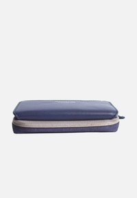Navy blue zippered wallet with a smooth texture, rectangular shape, and tan zipper accents. Features a logo on the front.