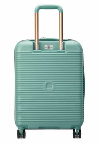 Valigia rigida di colore verde menta, con texture a righe, manico retrattile in rame e quattro ruote per la mobilità.