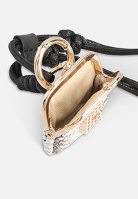 Pochette à monnaie argent métallique avec une texture de peau de serpent, ferrures dorées et une doublure beige douce, attachée à une sangle noire tressée.