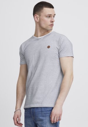 Short-sleeve t-shirt, gray with navy stripes, round neck, featuring a small brown logo accent on the chest, paired with blue jeans.