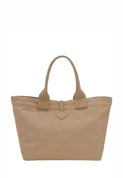 Beige canvas tote bag with dual textured handles, a stitched top seam, and a triangular leather accent at the center.