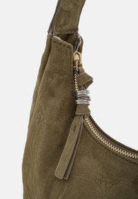 Borsa a tracolla in camoscio verde oliva con una cerniera dorata e dettagli hardware argento. Presenta una superficie testurizzata e un elegante dettaglio con nappina.