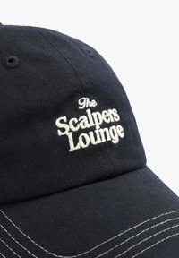 Gorra de béisbol azul marino de tela, con texto bordado en blanco que dice "The Scalpers Lounge" y costuras en contraste en el ala.