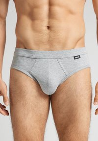 Grijze katoenen boxershorts met een gladde textuur, voorzien van een brede elastische tailleband en een voorpandontwerp. Eenvoudig zwart label op de tailleband.